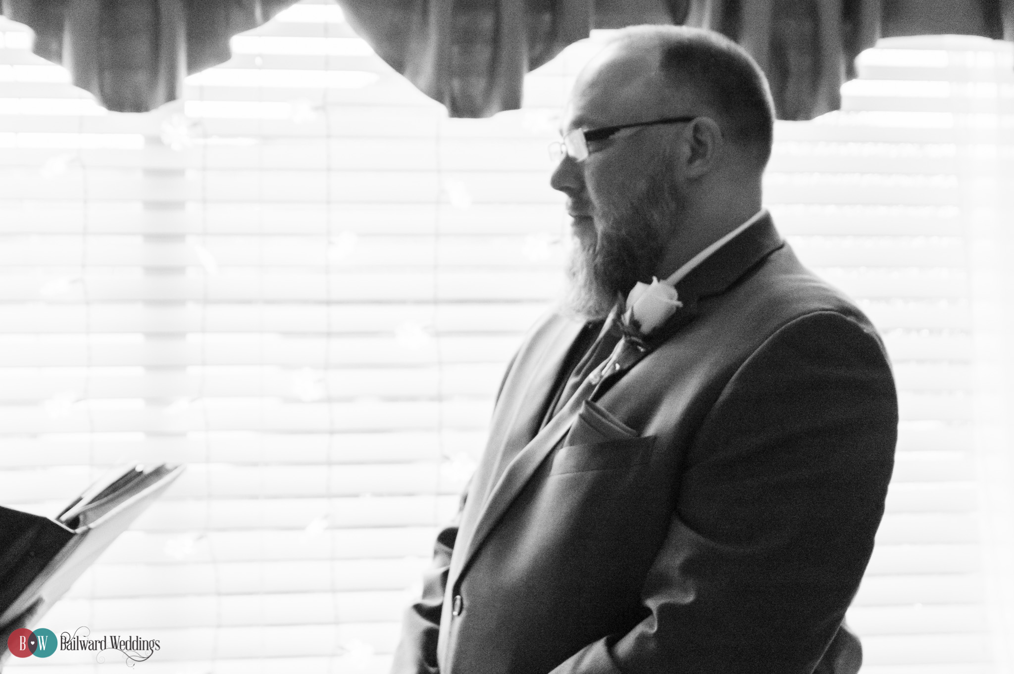 Groom looking at bride in black and white