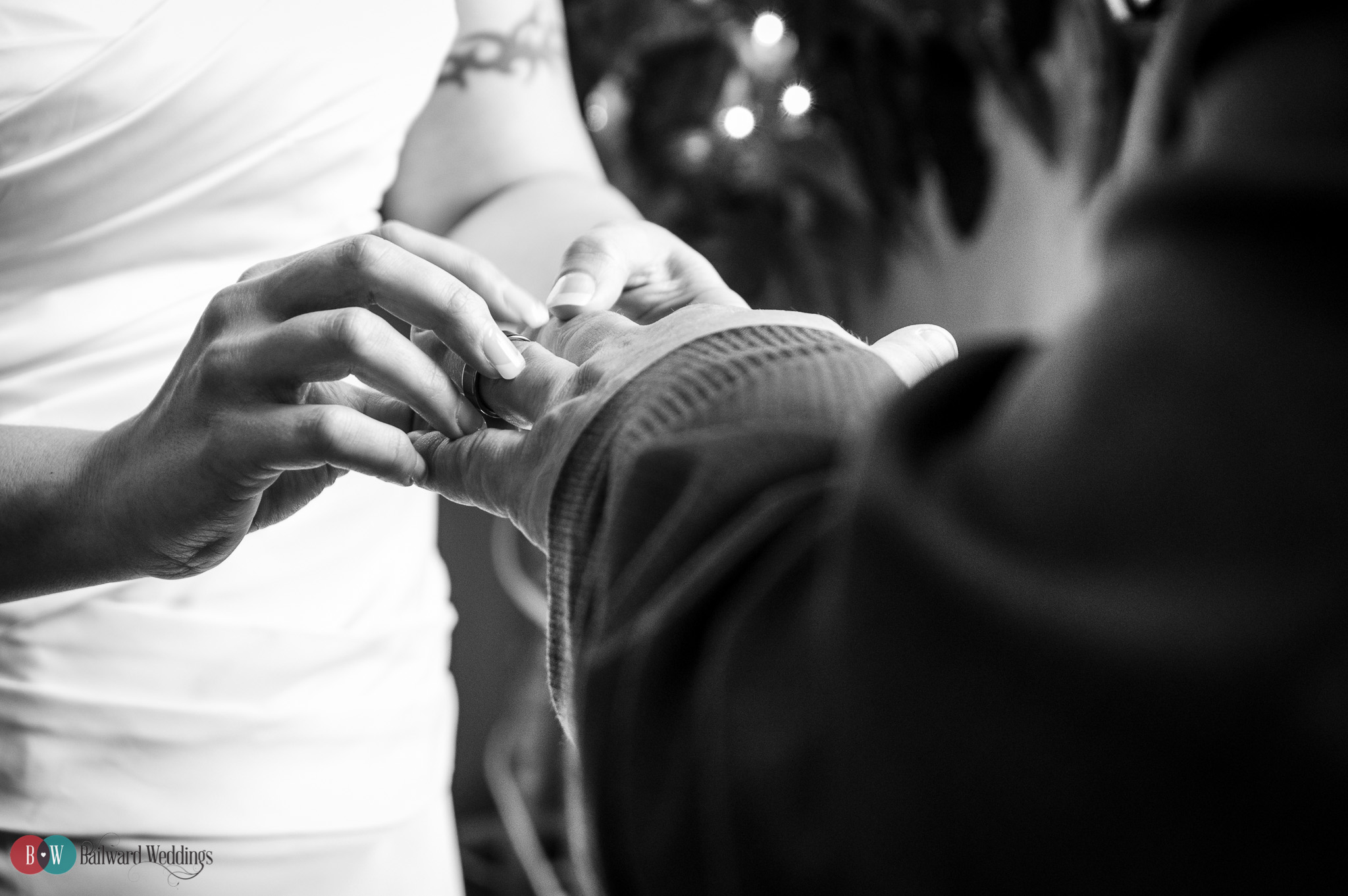 Bride putting ring on groom's hand