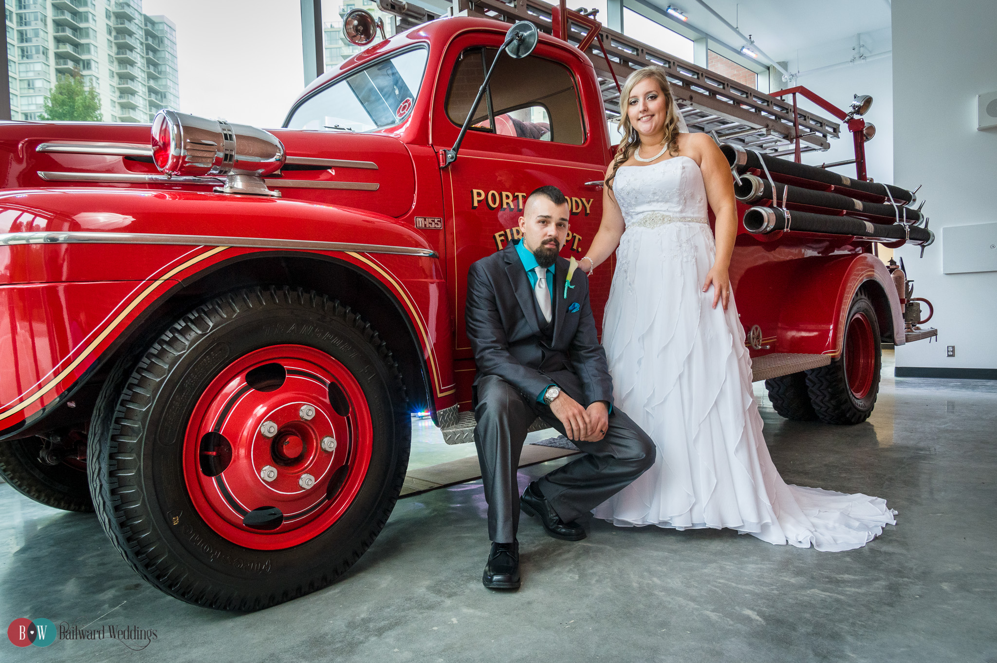 Bride and Groom posing beside red fire truck