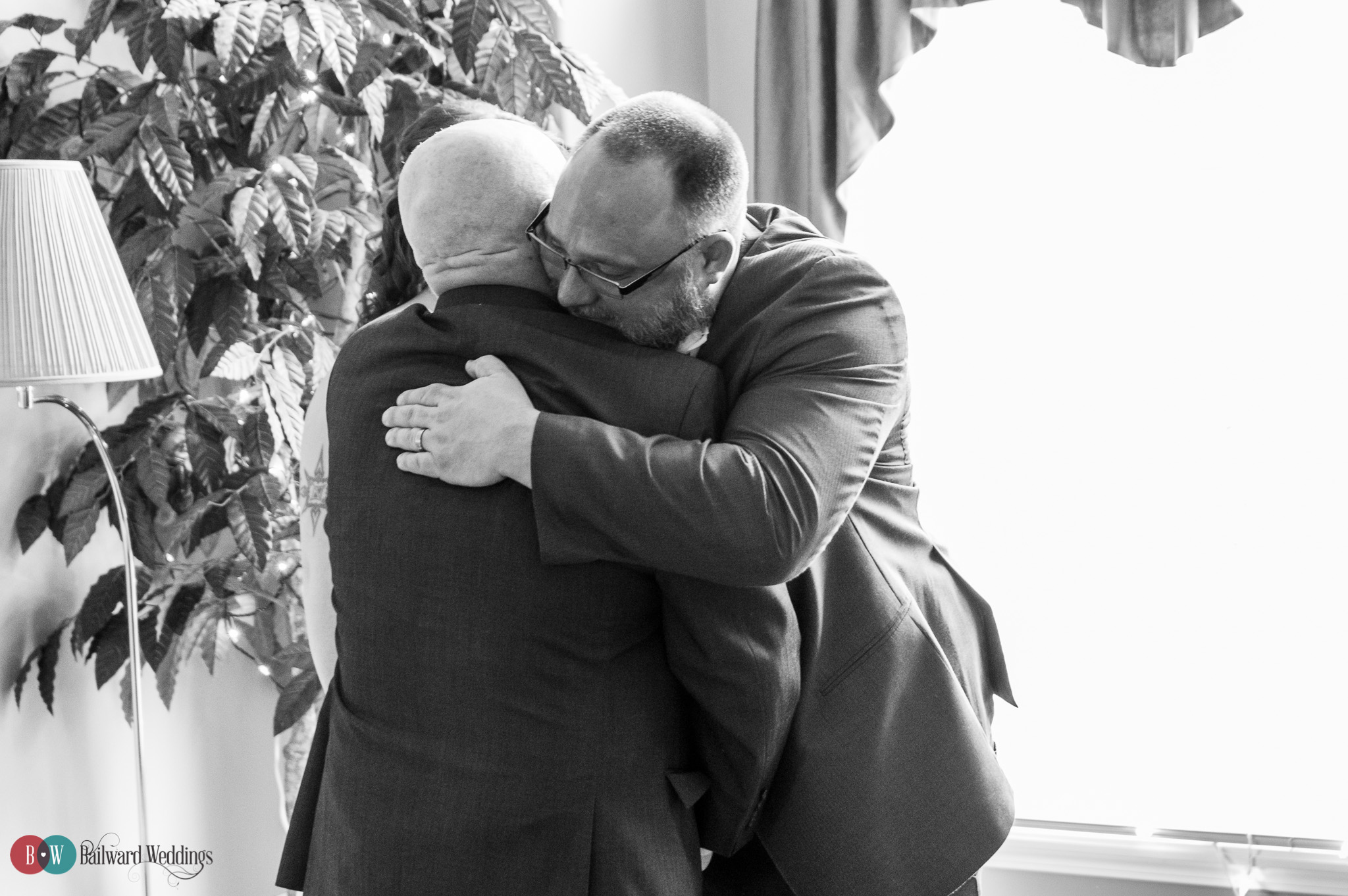 Father of the bride hugs groom