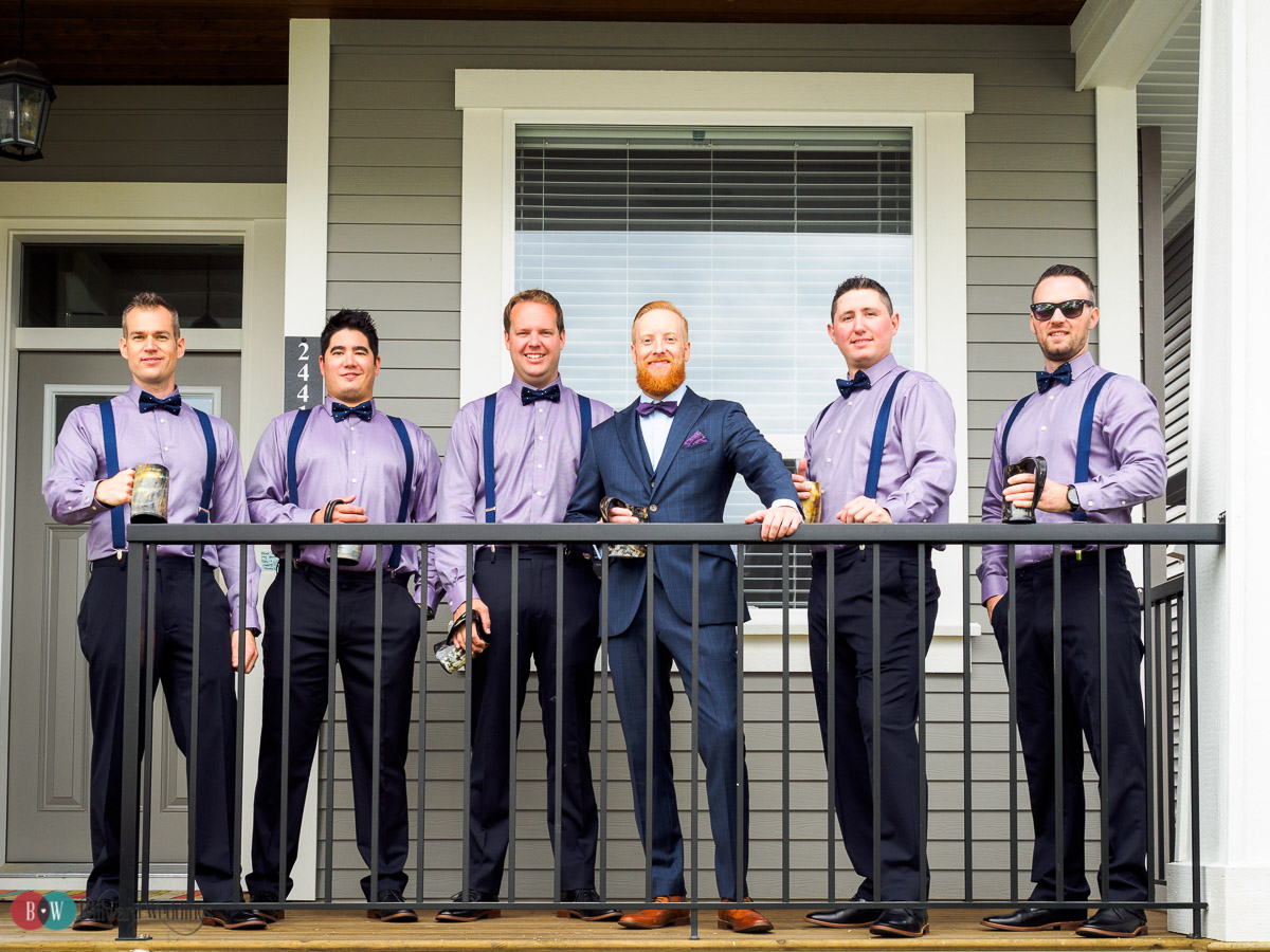 Groom and groomsmen in a line standing on deck